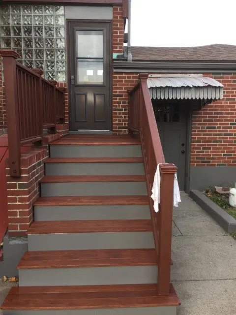 A set of wooden stairs leading up to a brick building