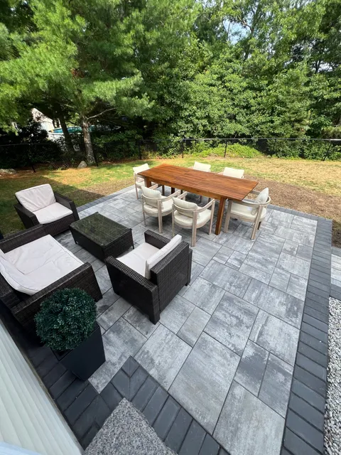 Finished paver patio with outdoor dining and lounge furniture