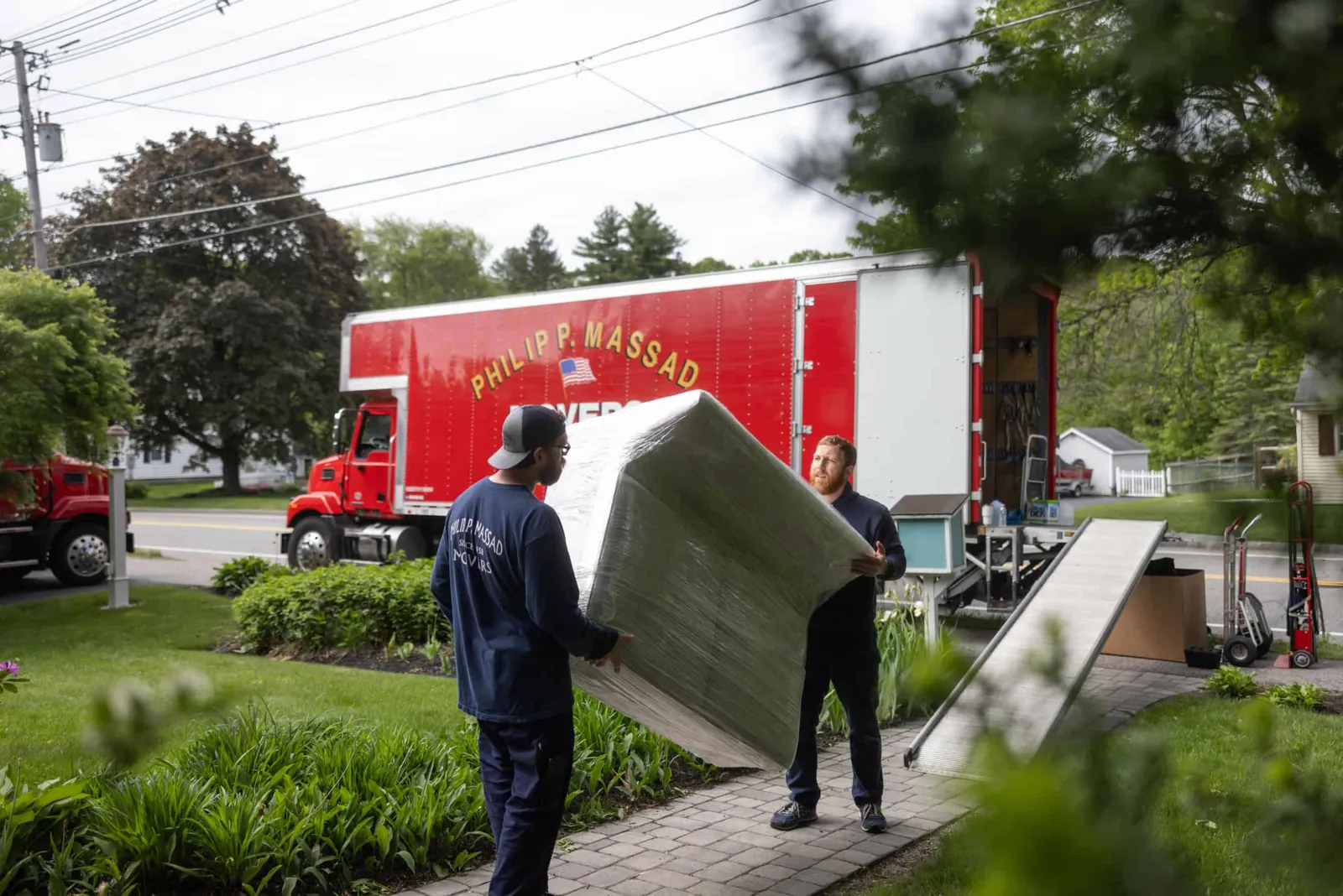 Two men unloading a large box from a truck.