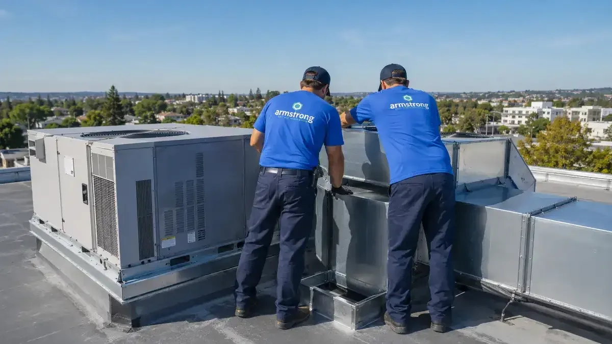 Armstrong crew servicing rooftop HVAC ductwork on a commercial building