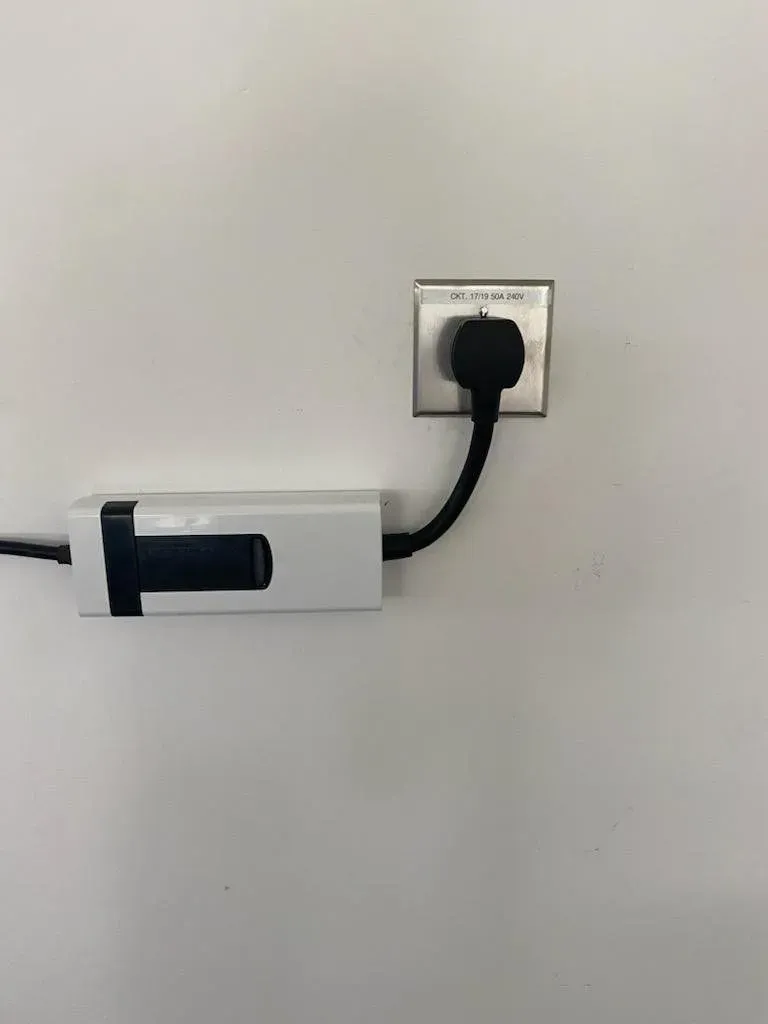 MJS Electrical Services - A power cord is plugged into a wall outlet.
