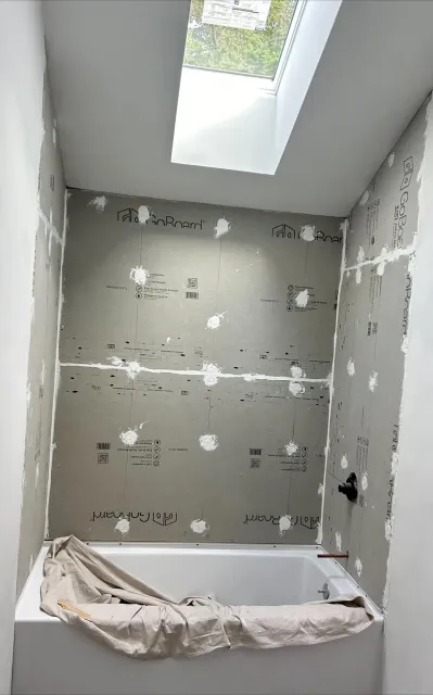 A bathroom under construction with a bathtub and a skylight.