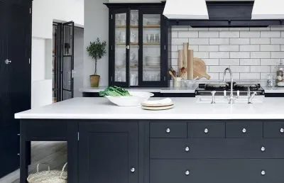 Kitchen remodeling features blue cabinetry and white quartz countertops.