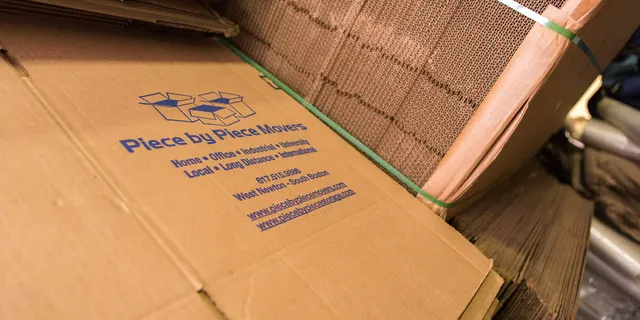 Company-branded moving boxes printed with 617.515.9886, West Newton / South Boston