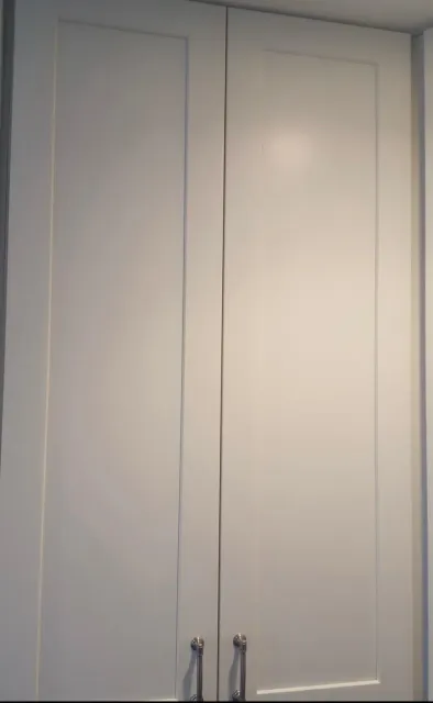 White double closet doors with silver handles in a room.