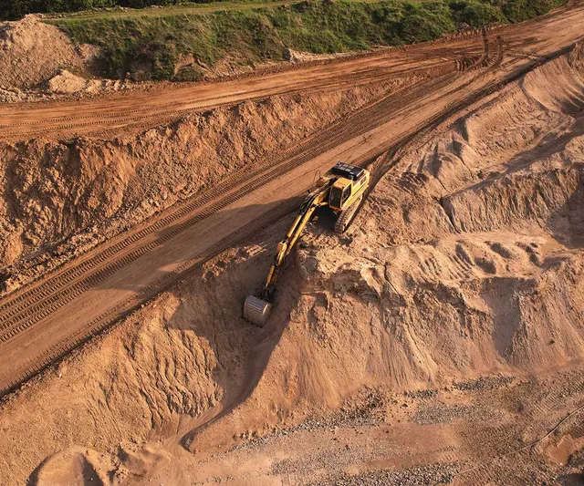 Excavator at grading and excavating site