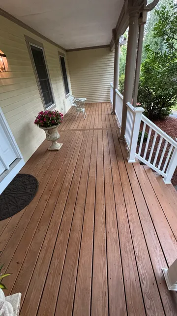 Front porch with freshly stained decking and white railings