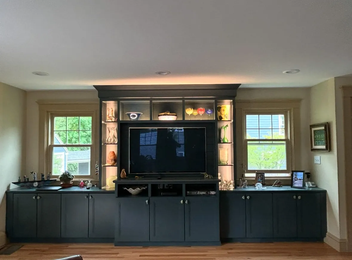 Living room cabinet with a TV and various decorative objects on shelves.