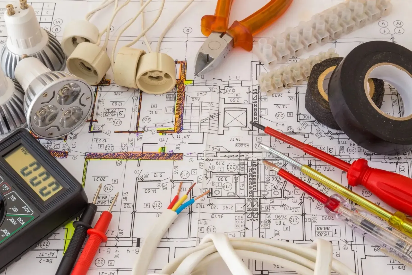 A bunch of electrical tools laying on top of a blueprint