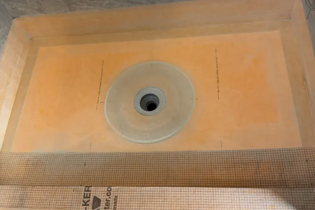 KERDI membrane sealed around the drain, curb and wall joints before tile — shower waterproofing by Dmtilellc in Newington, CT