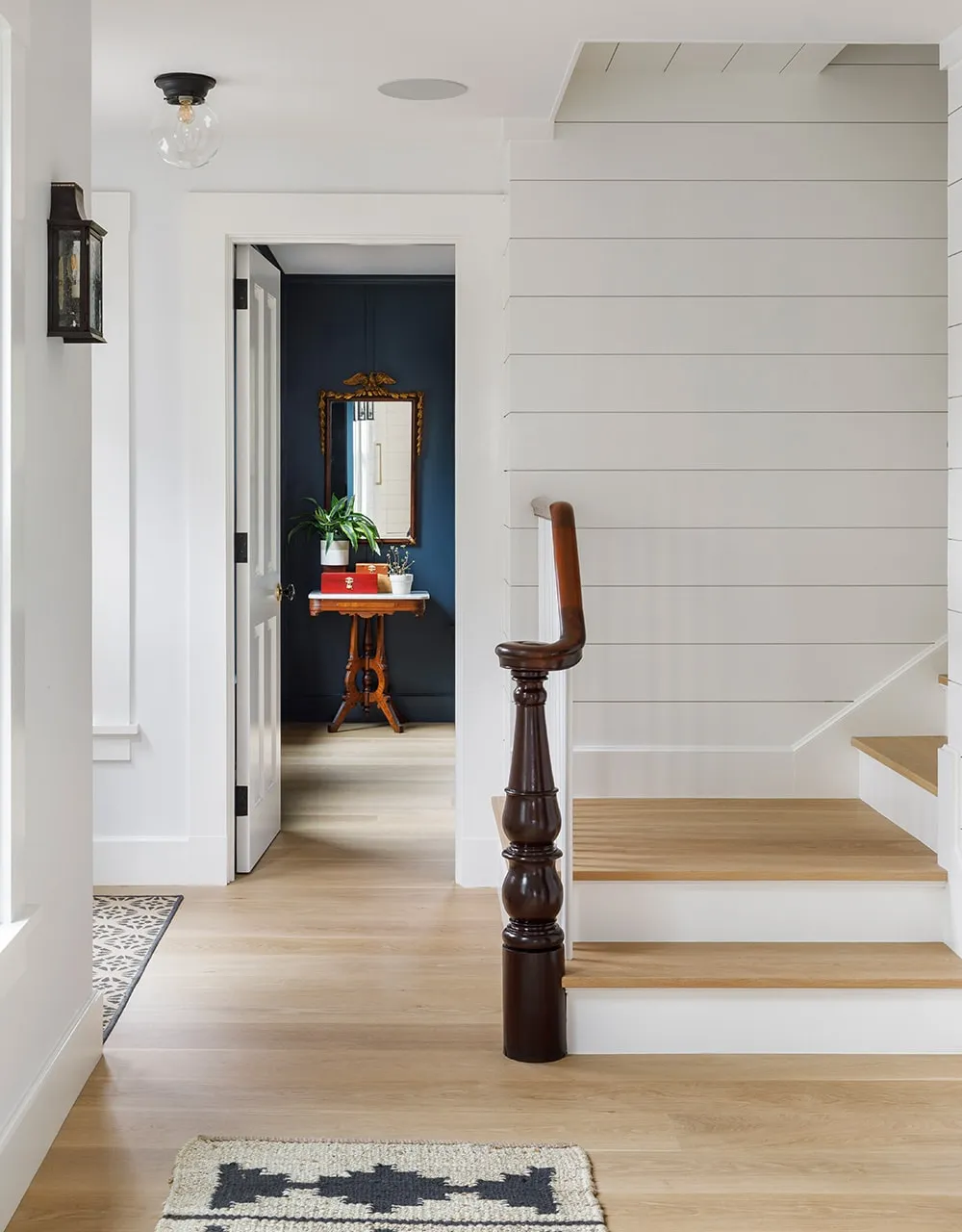 House foyer with white staircase and light wood floors