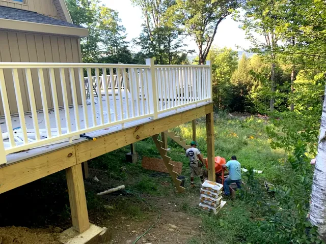 Crew framing stairs under an elevated deck