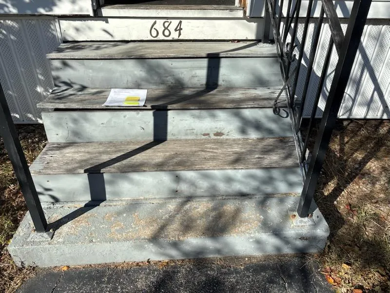 Front steps before repair with worn concrete and railings