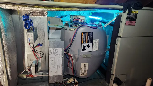 Interior of an air conditioning unit showing various components, wiring, and a UV light installed inside.