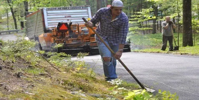 Man Holding Rake — Lunenburg, MA — Miller’s Paving, LLC