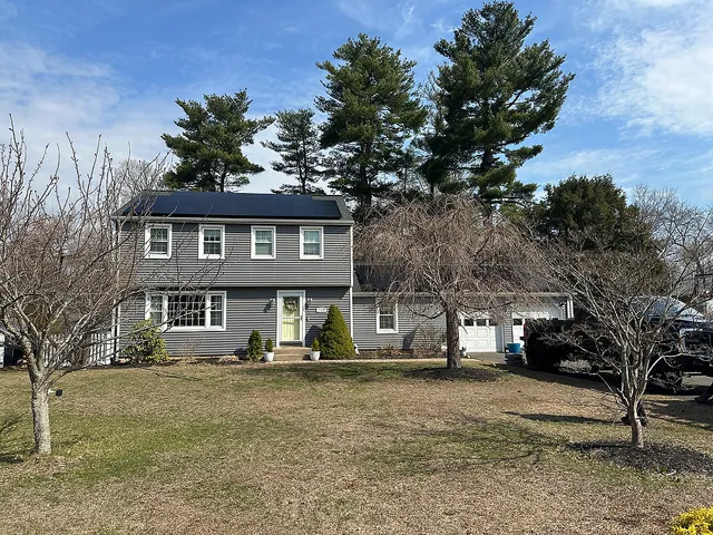 Solar installation on colonial home with trees