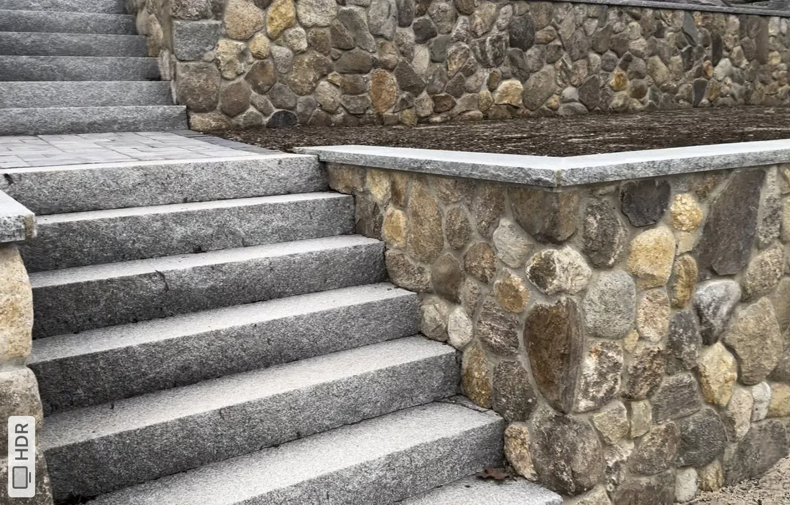Granite masonry stairs framed by natural stone walls