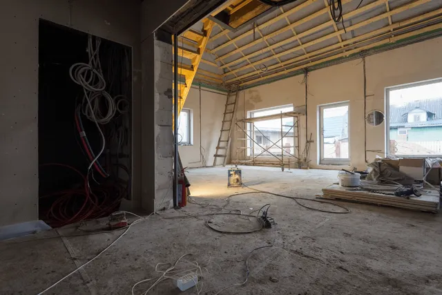 Room under renovation with construction tools and materials.