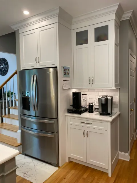 A kitchen with stainless steel appliances and white cabinets
