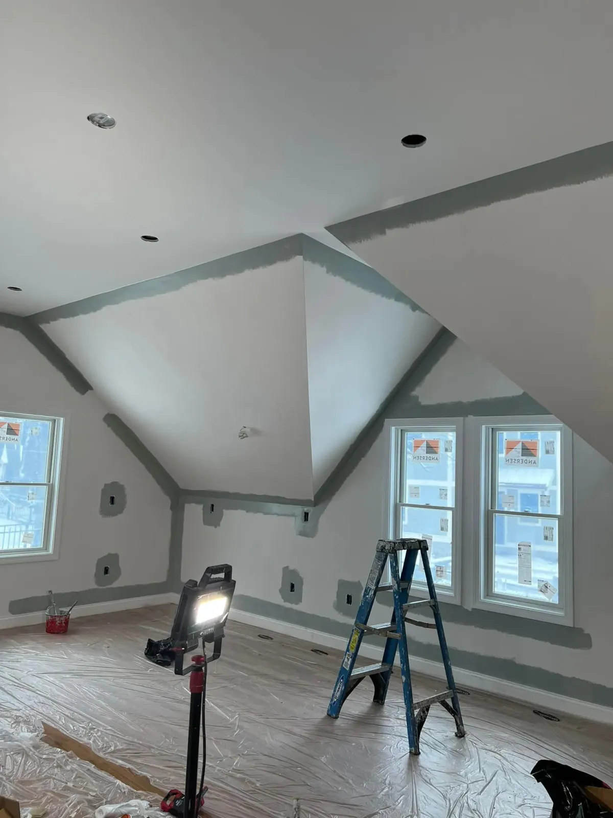 A room with a ladder and a light on the floor.