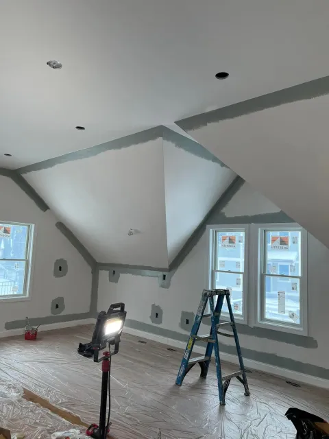 A room with a ladder and a light on the floor.
