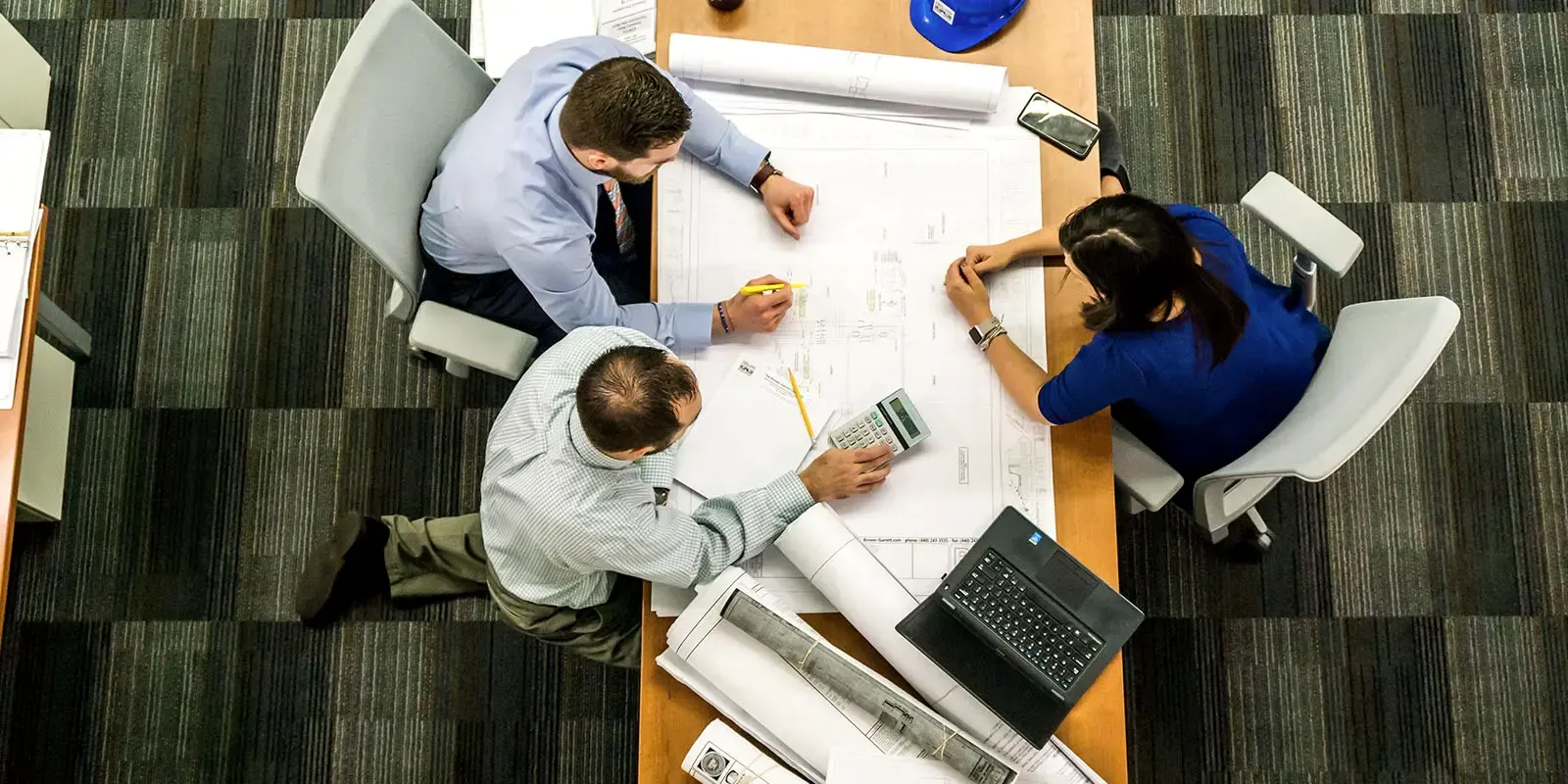 Project team reviewing electrical plans around a table