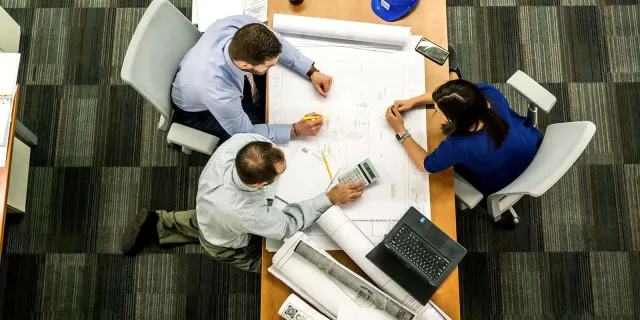 Project team reviewing electrical plans around a table