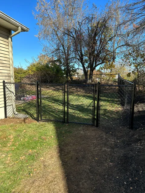 There is a fence in the backyard of a house.