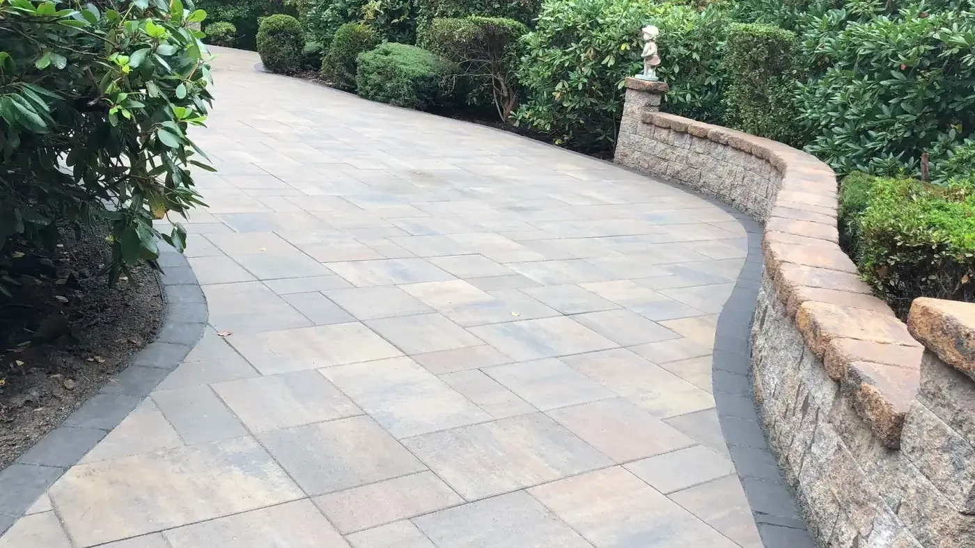 Curved paver walkway edged by a natural fieldstone wall