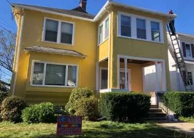 freshly painted yellow house after extensive stucco restoration