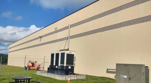 A large building with a lot of machinery in front of it.