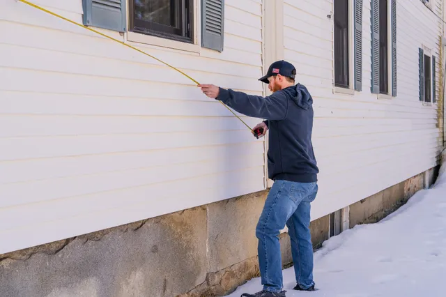Service advisor form M.W. Sewall uses tape measure for installing propane tanks