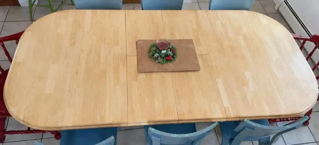 Wooden dining table with a holiday centerpiece in the middle.