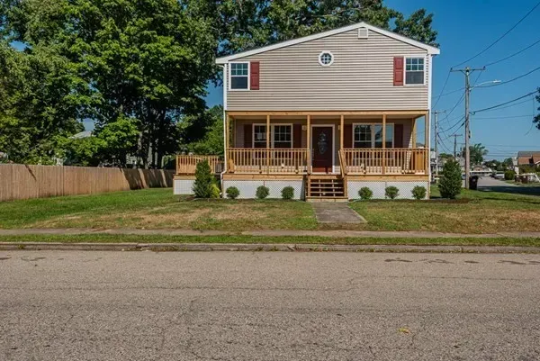 A large house with a large porch is sitting on the side of the road.
