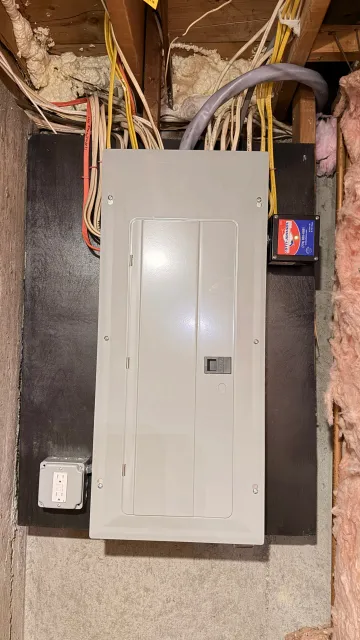The completed electrical service change, highlighting the newly installed, fully enclosed, and cleanly mounted electrical panel.