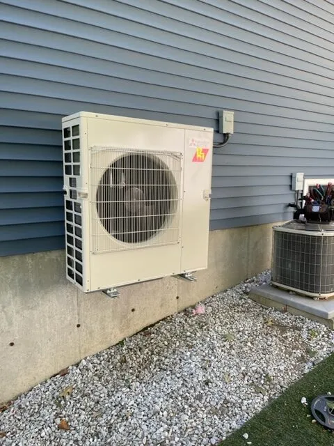Mitsubishi cold-climate heat pump mounted securely above ground level