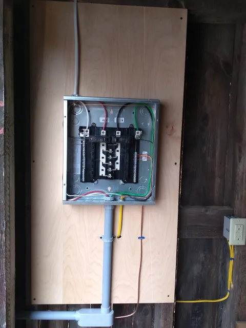 a electrical box is mounted on a wooden wall .
