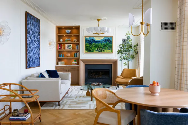 Living room with a wood-toned fireplace surround, built-in shelving, and framed artwork