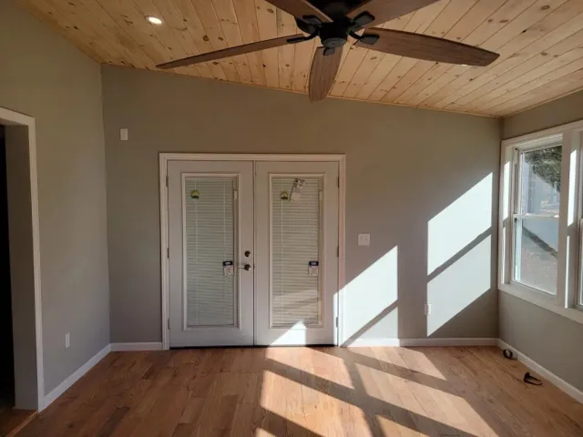 A living room with hardwood floors and a ceiling fan.