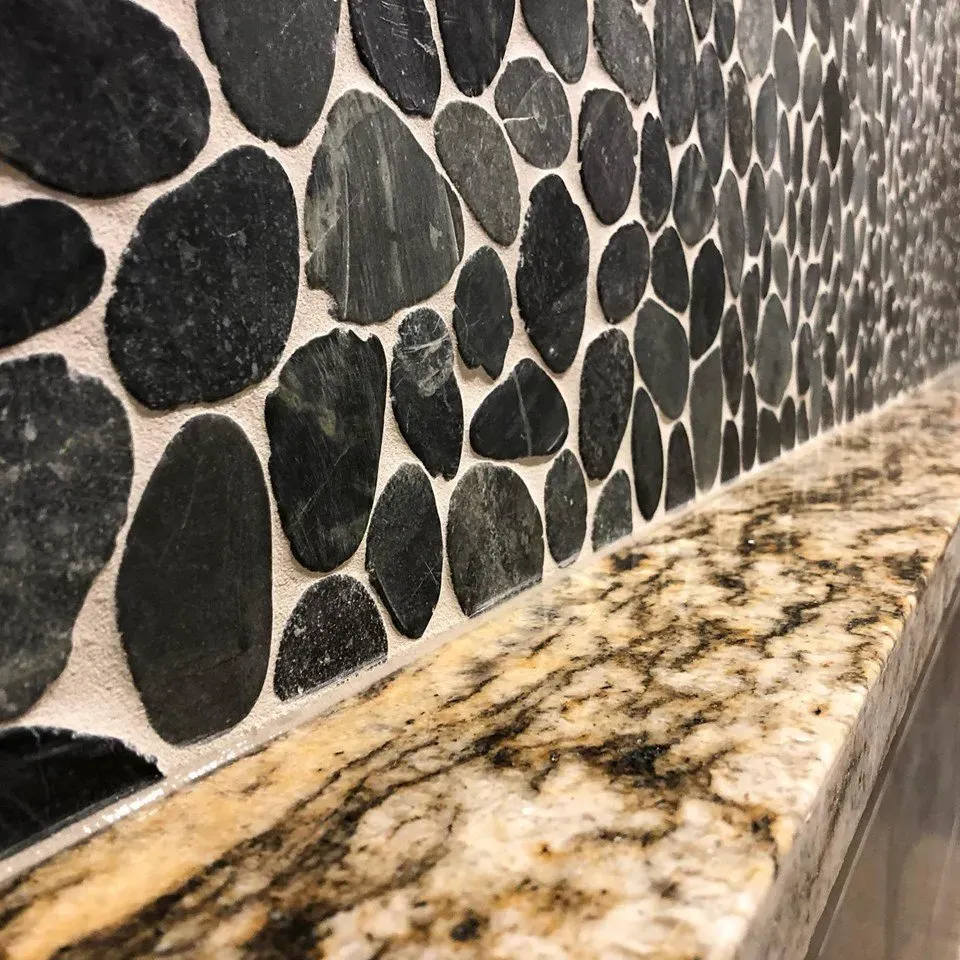 A close up of a stone wall with a granite counter top