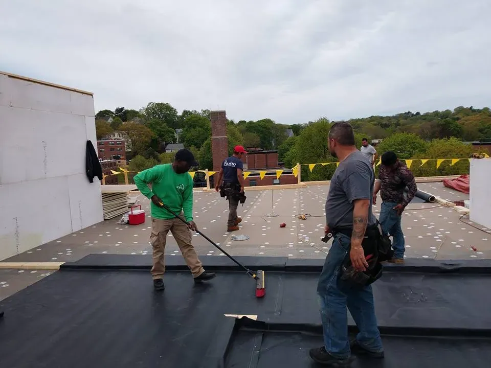 Kyne Roofing & Construction people waterproof coating on roof