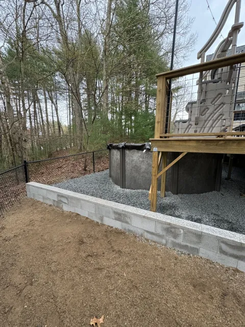 A wooden deck with a swimming pool underneath it.