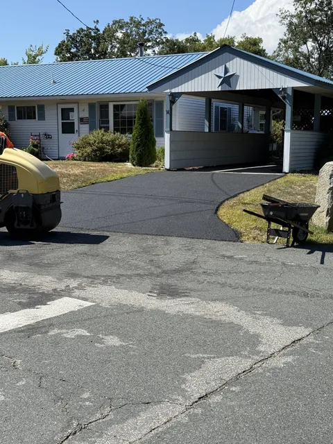 Curved asphalt driveway leading to a carport