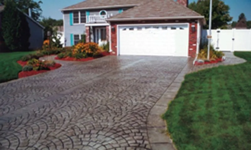 Fan-pattern stamped concrete driveway with colonial home