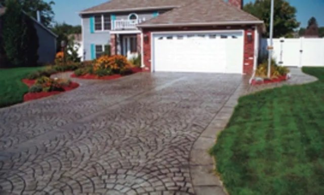 Fan-pattern stamped concrete driveway with colonial home