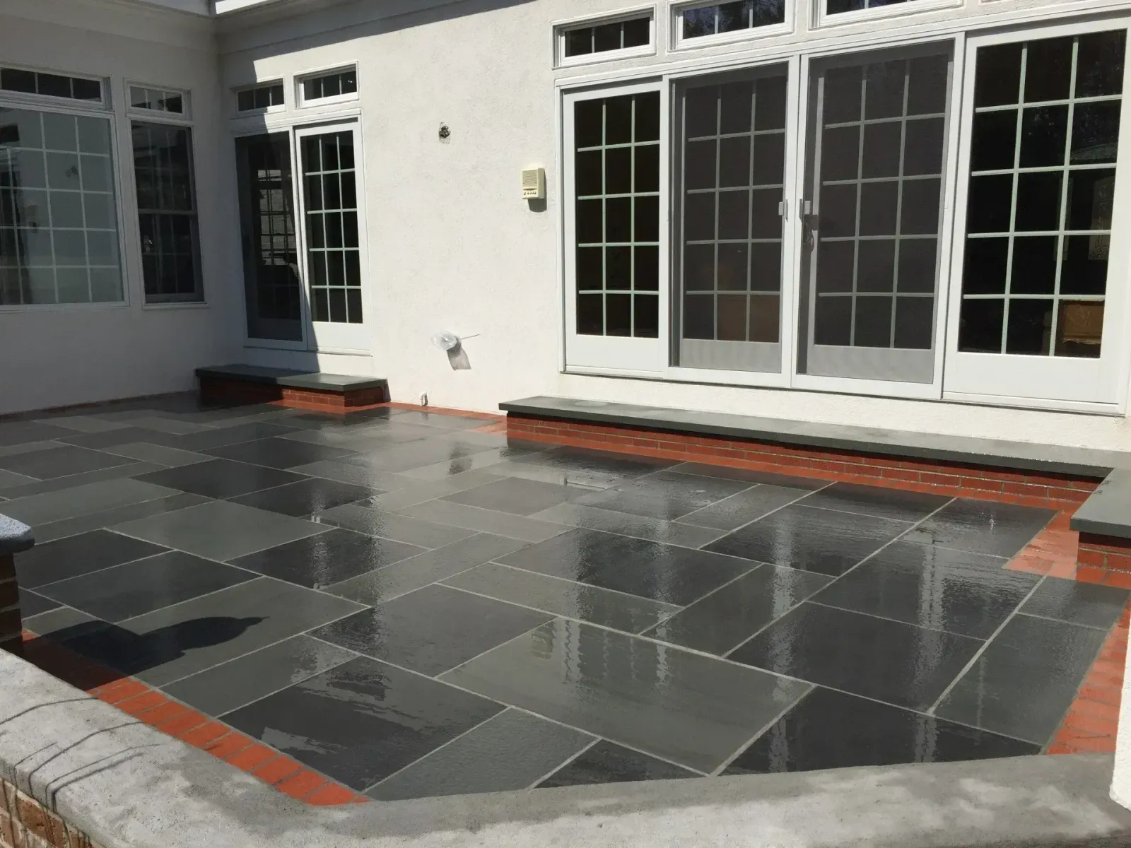 A patio in front of a house with sliding glass doors