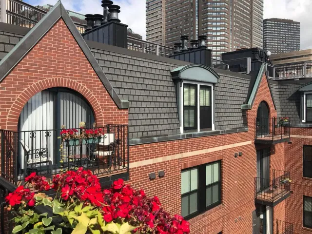 A brick building with a balcony and flowers on it