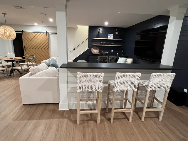 Finished basement bar with navy shiplap and custom barn door