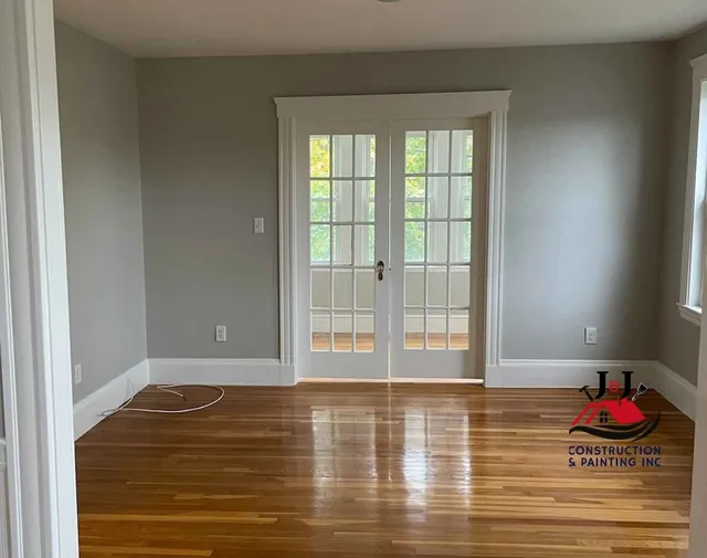 Repainted room with restored hardwood floor and French doors
