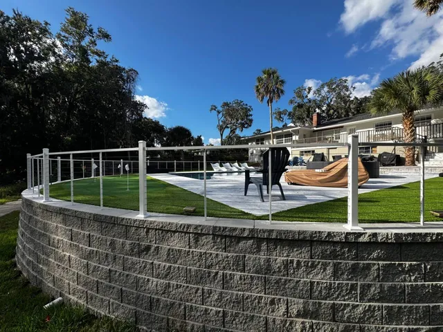 Elevated yard with retaining wall and SuperNatural Lite synthetic turf, perfect for recreation and modern outdoor design Jacksonville FL
